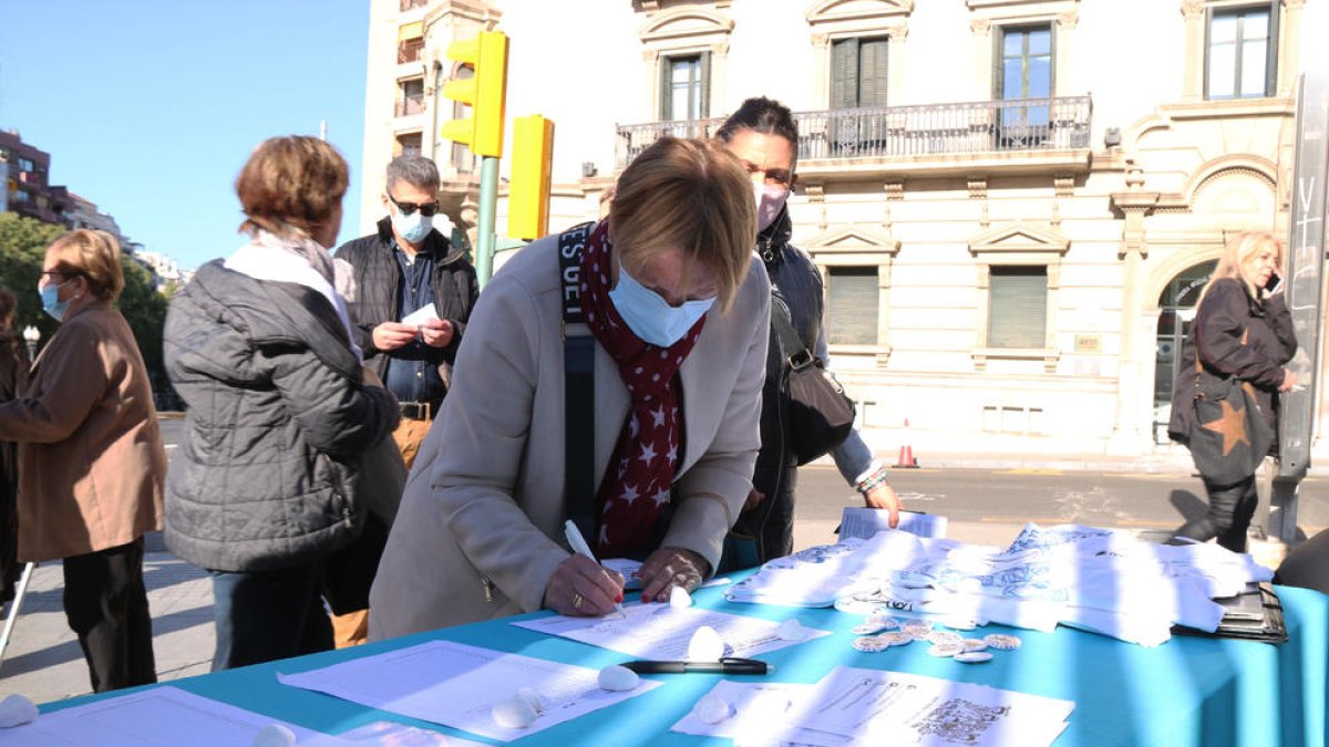 Una mujer firmando las peticiones hechas por los miembros del grupo.