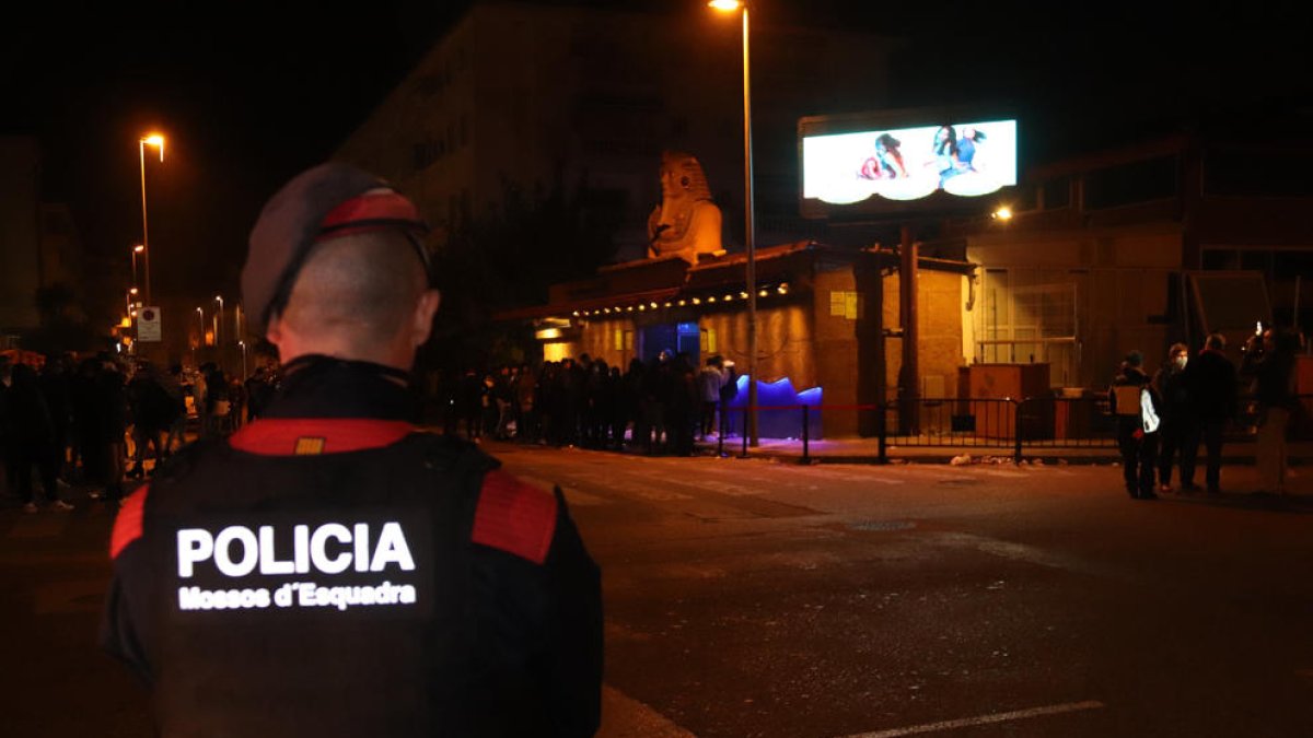 Pla obert d'un agent dels Mossos d'Esquadra vigilant els joves que hi ha als accessos de la discoteca Arena de Blanes