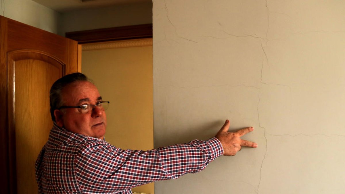 Plano medio de José Miguel Monllaó mostrando una grieta a la pared de una habitación de su casa de Amposta causada por los terremotos del proyecto Castor.