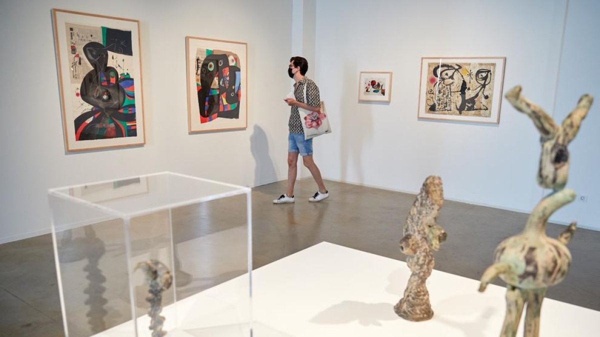 Una persona observant l'exposició compartida per Miró i Gaudí.