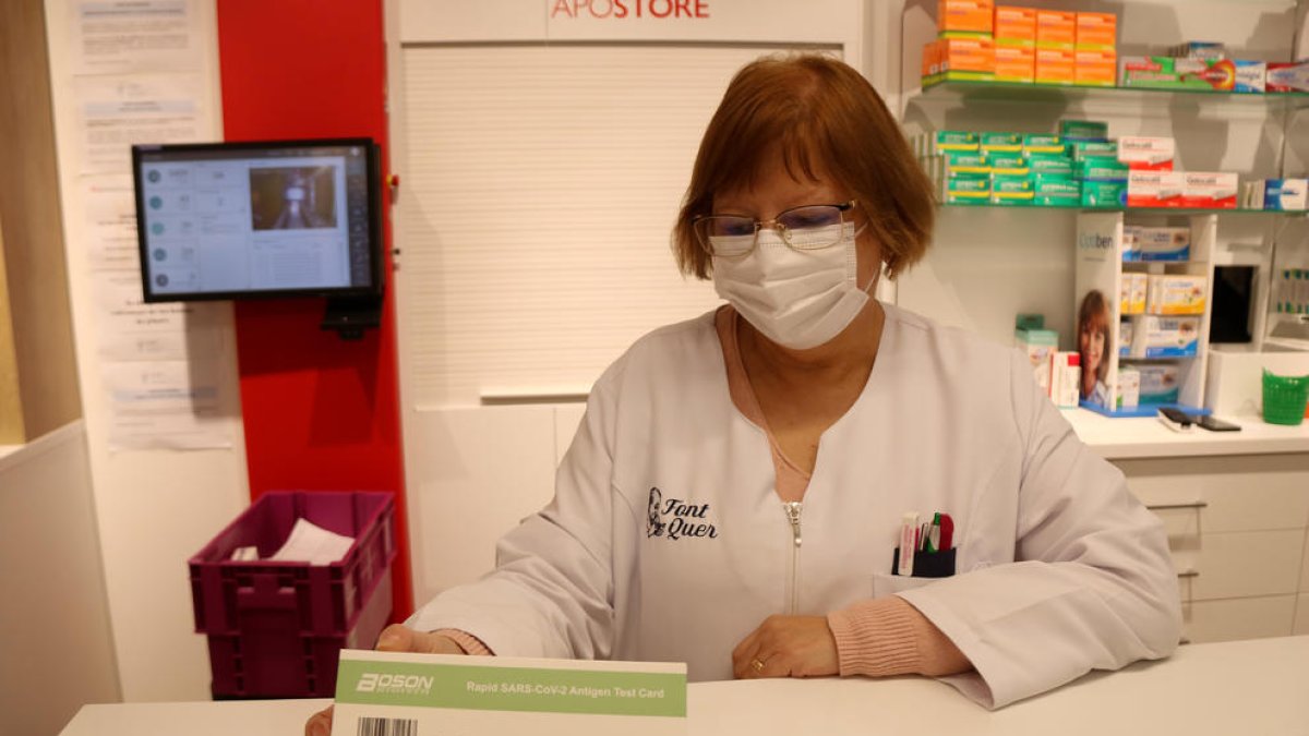 Una farmacéutica de Tarragona con un test de antígenos.