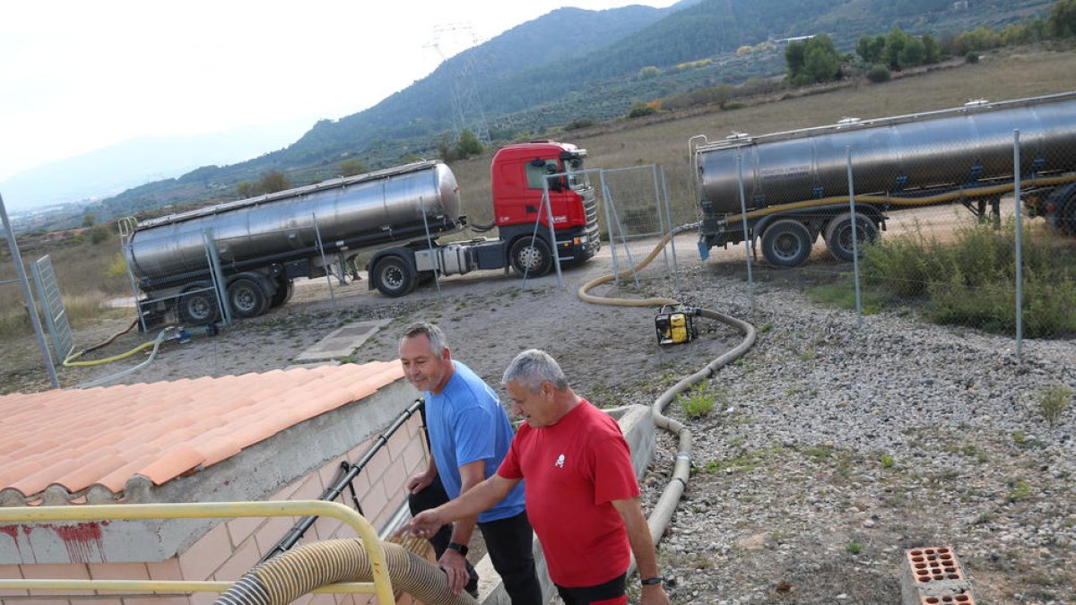 Unos operarios traspasando agua de los camiones cuba al depósito de l'Espluga de Francolí, por la situación de sequía que sufre.