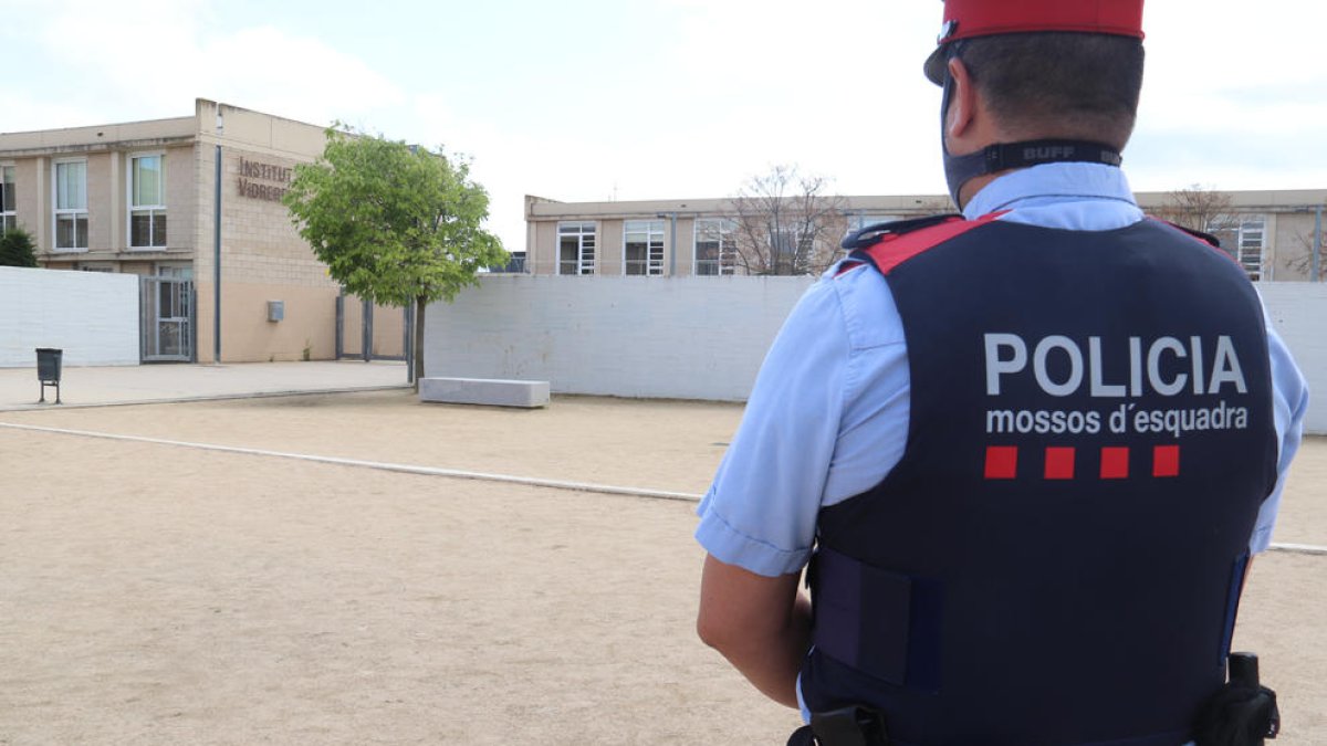 L'l'institut de Vidreres amb un agent dels Mossos d'Esquadra en primer terme d'esquenes, després de l'incident.