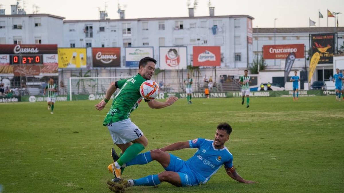 Joan Oriol realitza una entrada a un rival durant l'Atlético Sanluqueño-Nàstic.