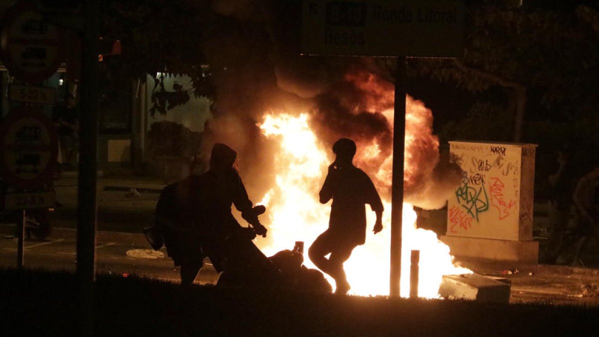 Dos jóvenes queman una moto durante los disturbios posterior al botellot del Bogatell