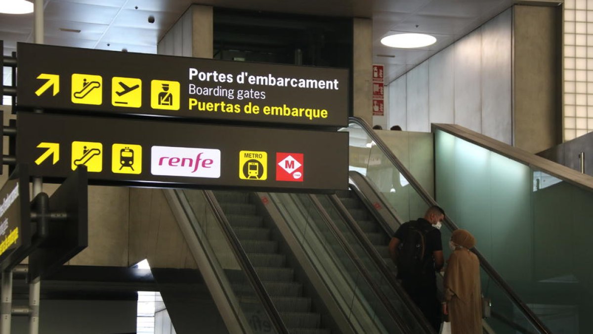 Pasajeros en dirección a la zona de embarque de la T2 del aeropuerto del Prat.