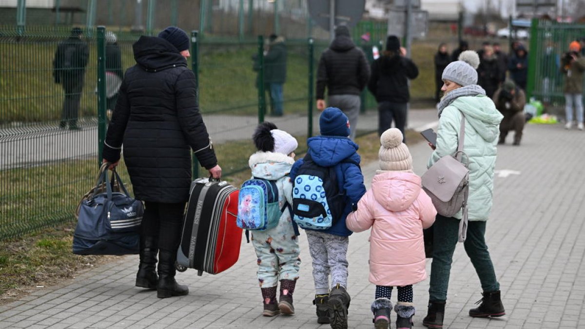Una familia ucraniana huyendo del conflicto bélico en dirección a Polonia.