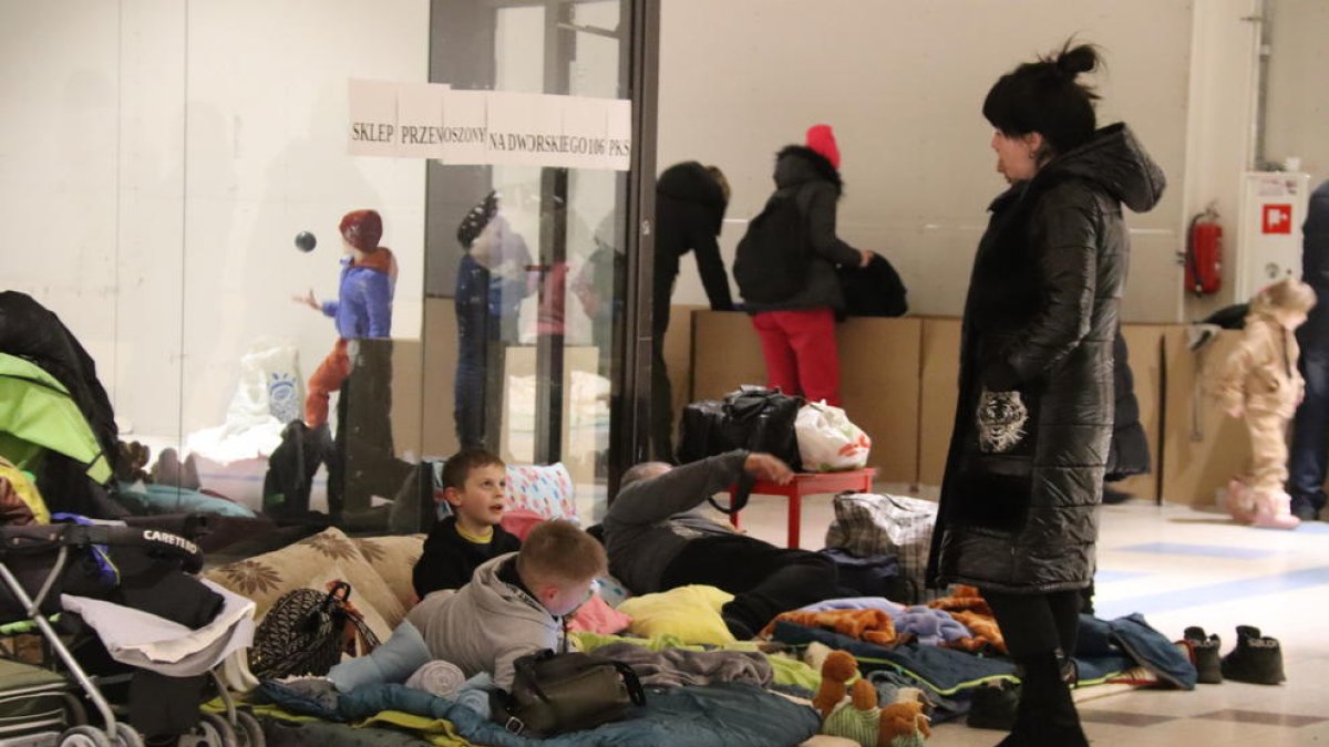 Niños ucranianos con sus familias en el centro comercial abandonado de Przemysl, reconvertido en centro de refugiados.