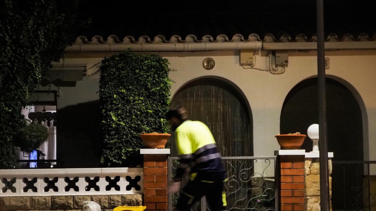 Plano general de un operario recogiendo los residuos en la puerta de una vivienda de Móra la Nova.