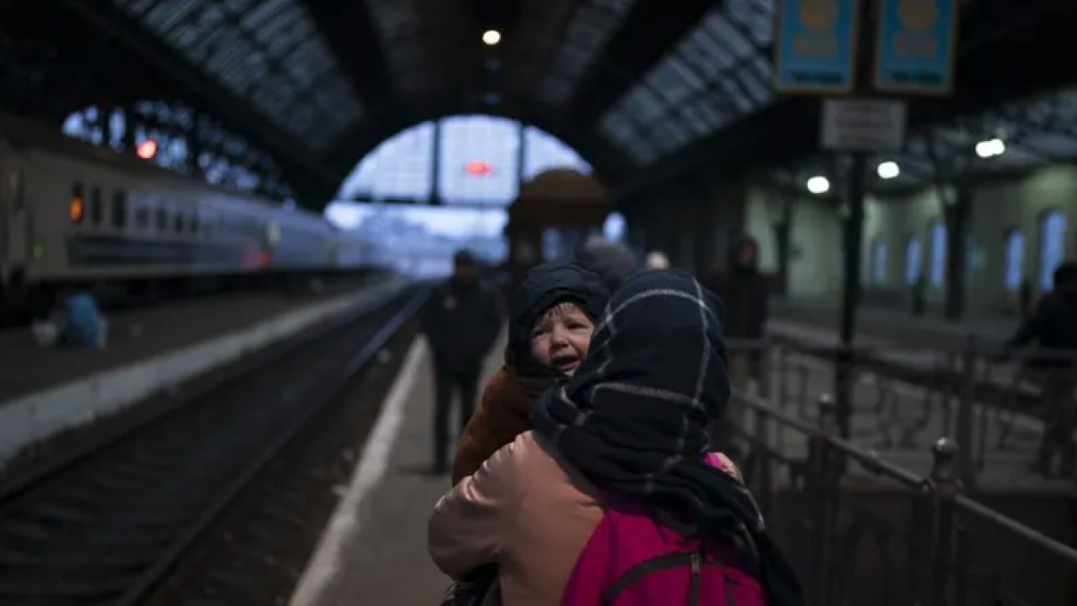 Una dona amb un infant a l'estació de tren de Lviv.