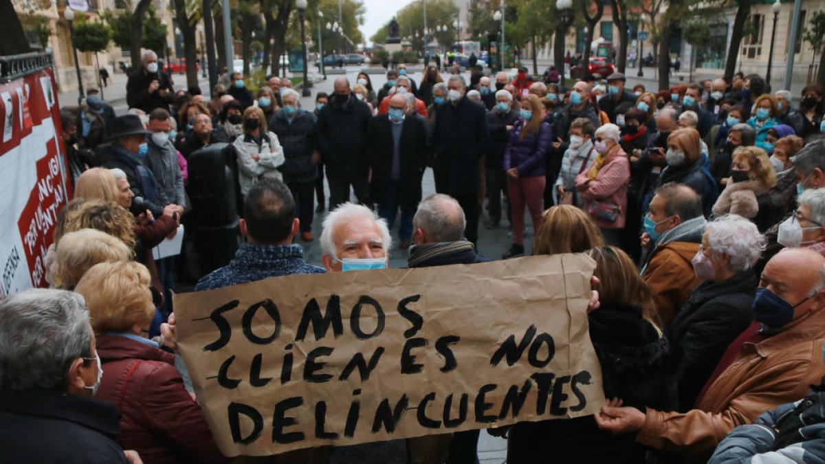 Un hombre muestra una pancarta en la protesta de este domingo en la Rambla Nova.