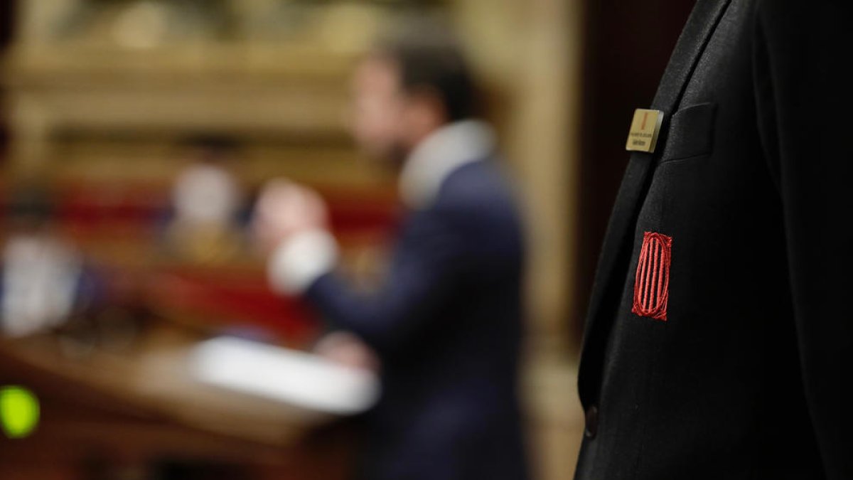 Escudo del Parlament en la solapa de la chaqueta de un trabajador de la cámara.