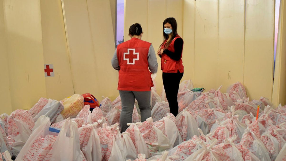 Pla general de dues voluntàries revisant les bosses de la Campanya de Joguines de la Creu Roja a Tarragona i l'Ebre.