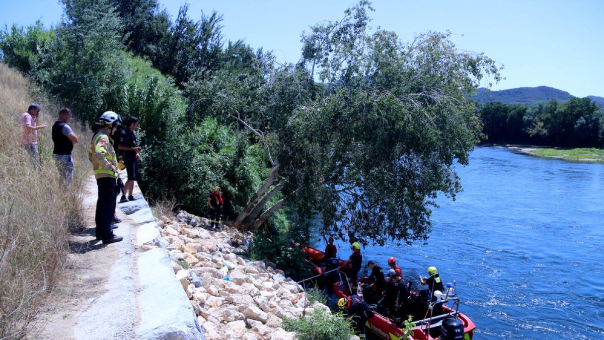 Operativo de búsqueda de los bomberos y los mossos buscando el cuerpo del joven desaparecido en el Ebe, en Benissanet, al punto dónde se tiró en el río para bañárse.