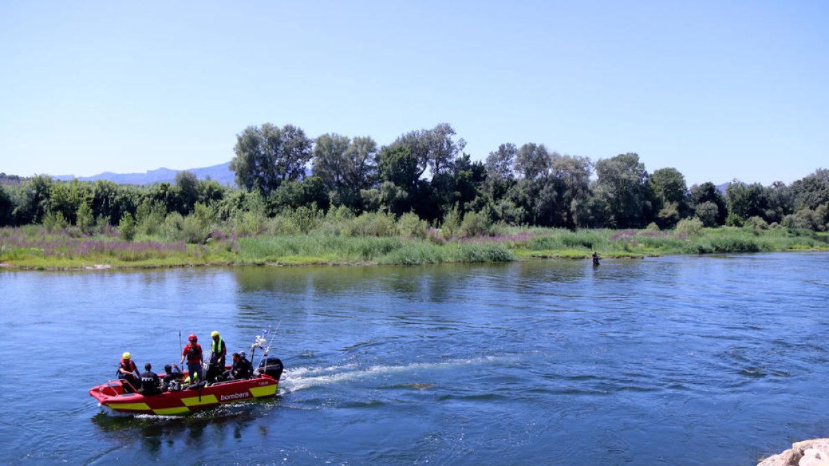Una embarcació dels bombers buscant el cos del jove desaparegut al riu Ebre, a Benissanet.
