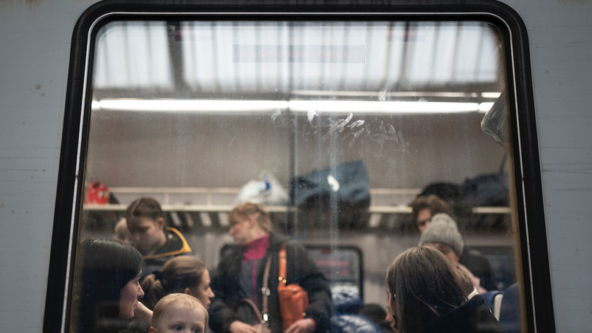 Estación de ferrocarriles de Lviv con civiles saliendo en tren.