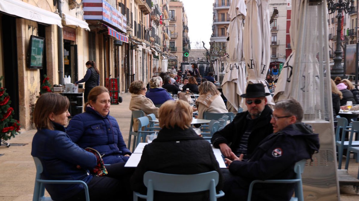 Pla general d'un grup de dones consumint en una de les terrasses dels restaurants de la plaça de la Font de Tarragona.