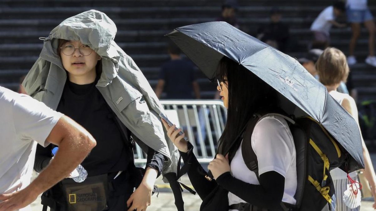 Uns turistes intentant protegir-se dels efectes del sol.