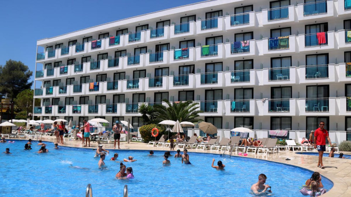 Turistes banyant-se a la piscina d'un hotel de la Pineda.