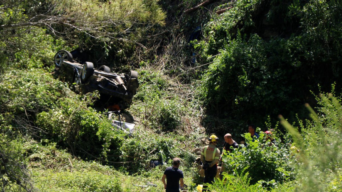 Efectivos de los Bombers y de los Mossos con el vehículo accidentado.