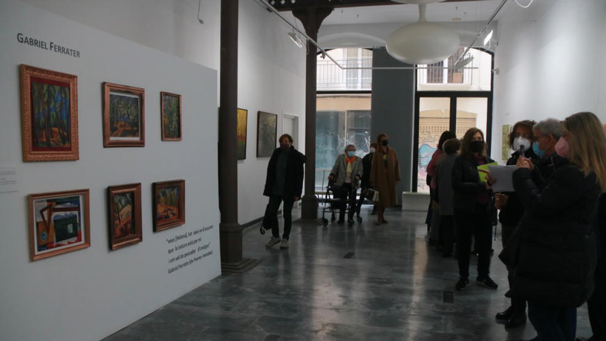 Una visitant fotografia l'exposició 'Gabriel Ferrater, pintor. Diàlegs inèdits'.