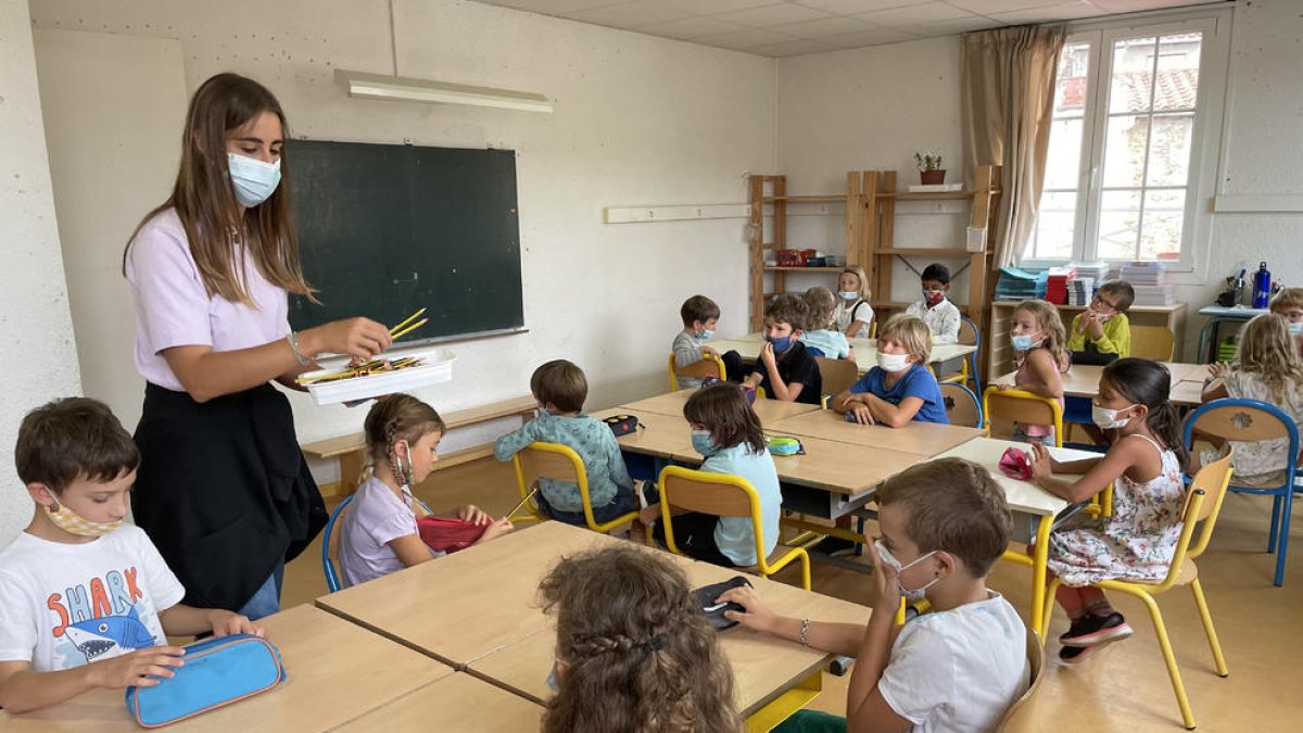 Una profesora de la Bressola dando el material a los alumnos en el primer día de clase.