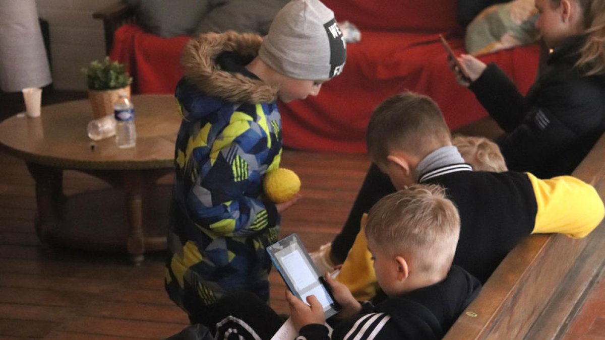 Varios niños refugiados jugando en la sala de estar de una casa de colonias.