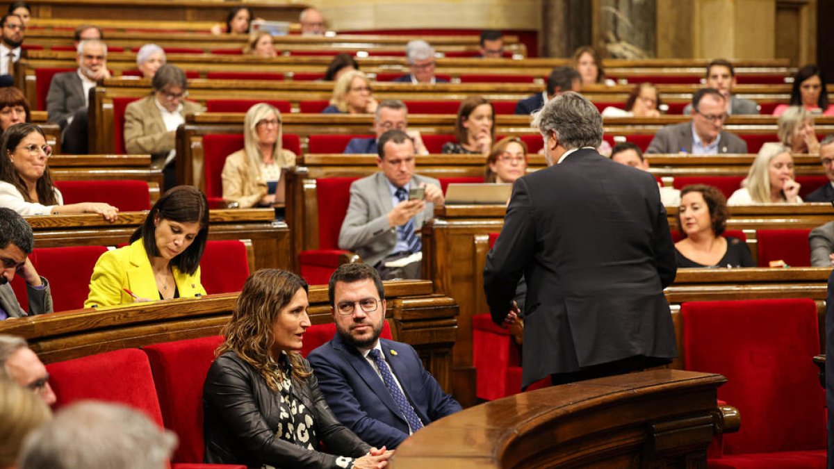 El presidente de Junts, Albert Batet, de espaldas con el presidente de la Generalitat, Pere Aragonès, sentado.