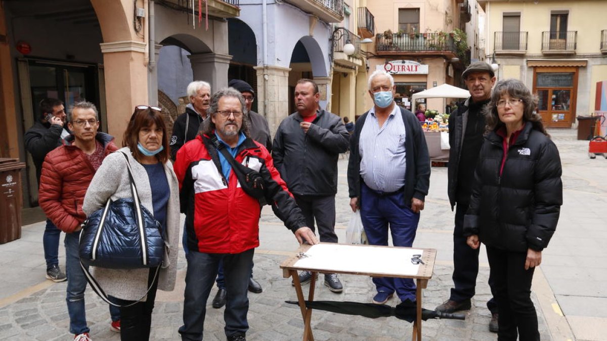 Paradistes del mercat amb un plànol on es dibuixa la seva nova ubicació, de la qual discrepen.