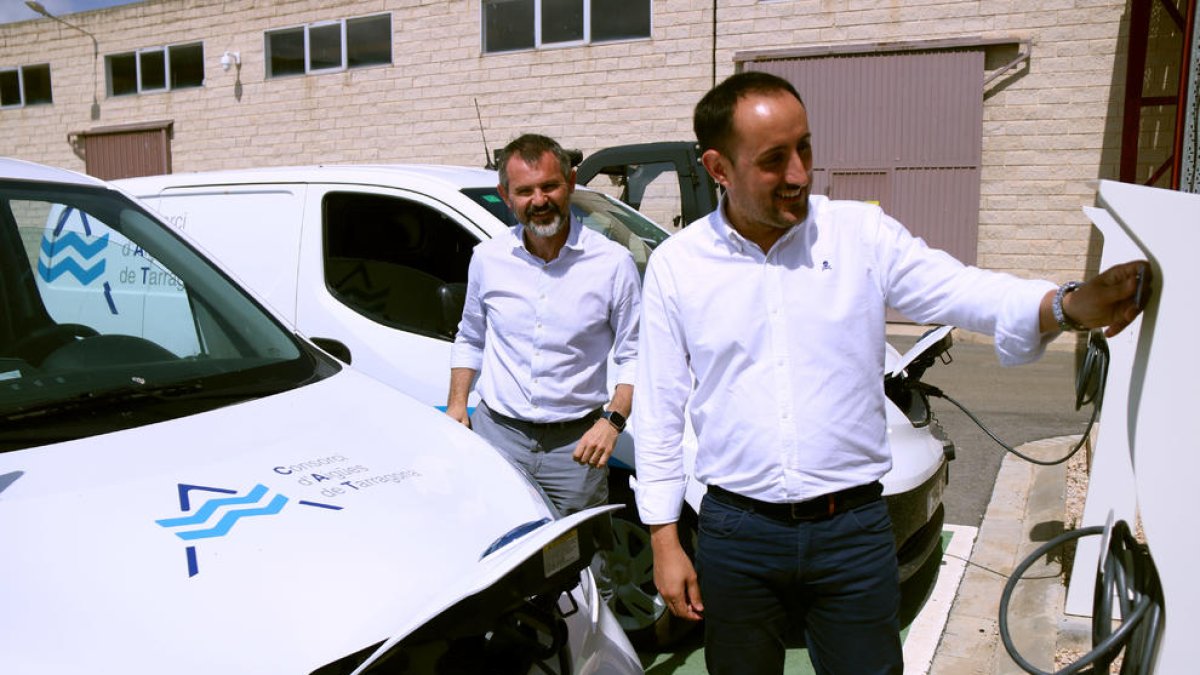 El presidente del CAT, Joan Alginet, en primero plano, y el jefe de innovación, tecnología y energía del CAT, Andreu Fargas, con uno de los nuevos vehículos eléctricos adquiridos en la planta potabilizadora de l'Ampolla.