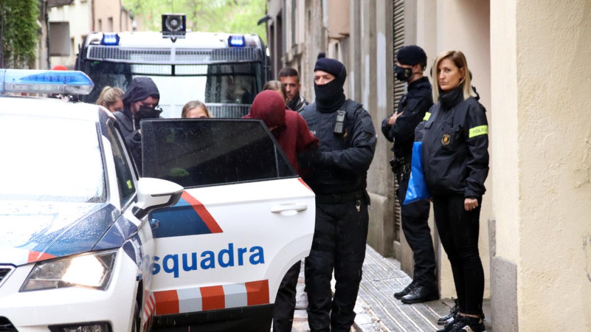 Salida del detenido después del cacheo de los mossos|mozos.