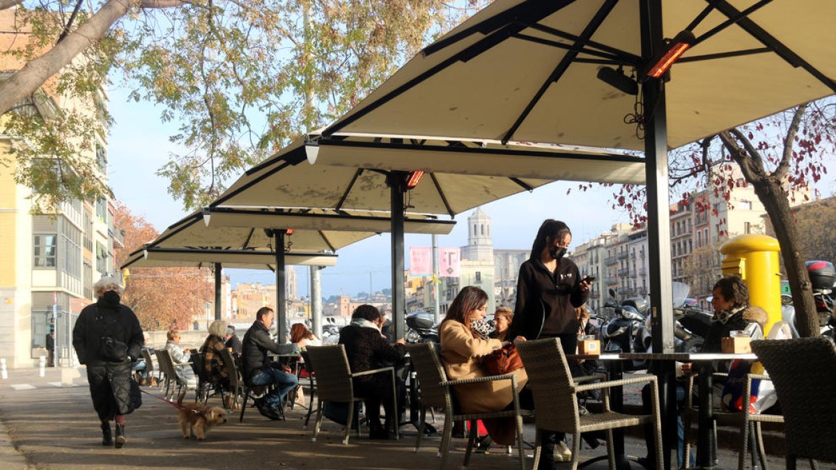 Clients esmorzant en una terrassa de la plaça Catalunya de Girona.