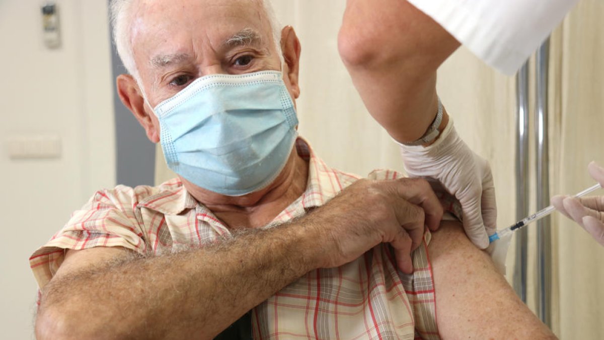 Un hombre se vacuna con doble dosis de gripe y covid en el CAP de Llefià.