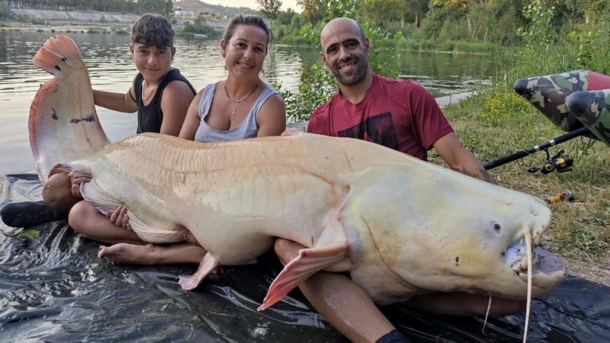 Juan Dalmau i la seva família amb el silur albí que han pescat al riu Ebre.