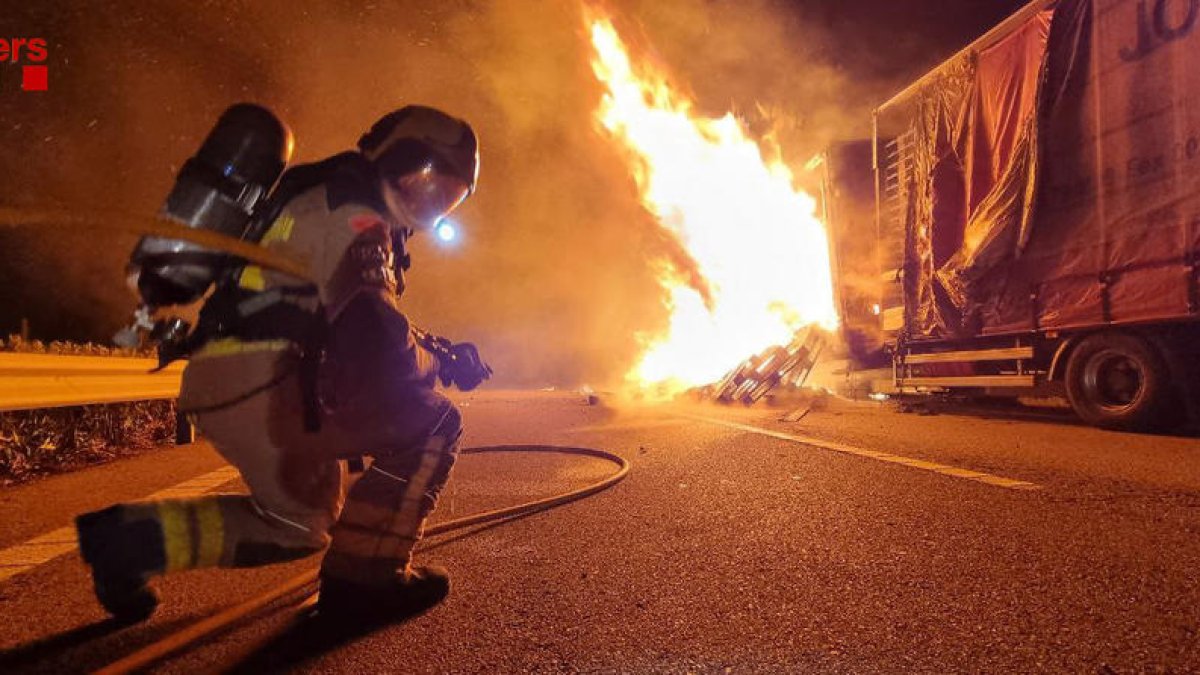 Un bombero extinguiendo el fuego del camión.