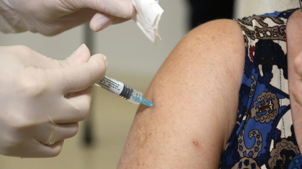 Una dona es vacuna amb doble dosi de grip i covid.
