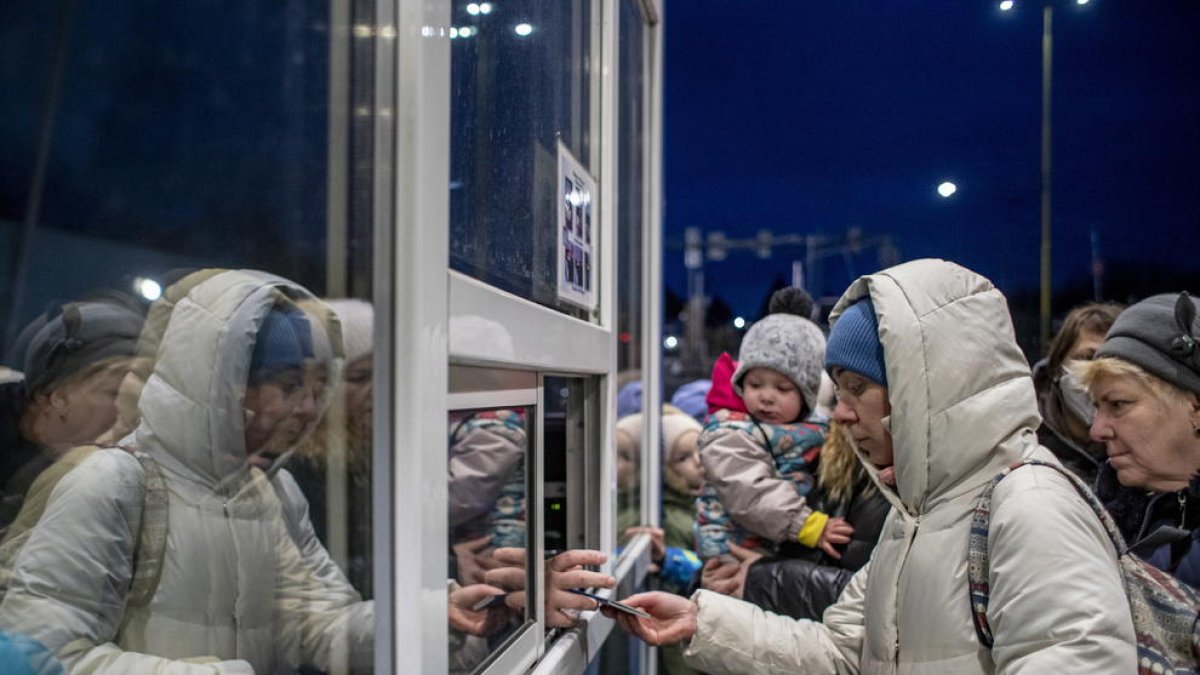 Una mujer entrega el pasaporte en la frontera entre Ucrania y Eslovaquia.