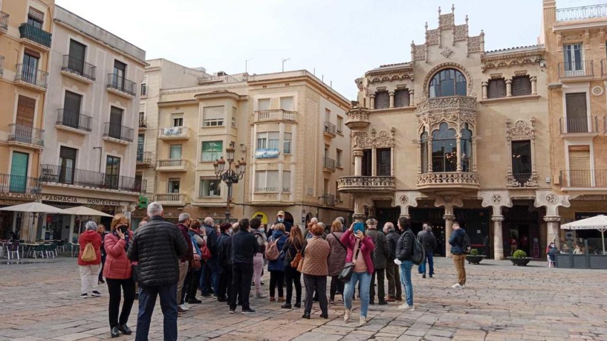 Un grup durant una visita guiada a la plaça del Mercadal, aquest dilluns.