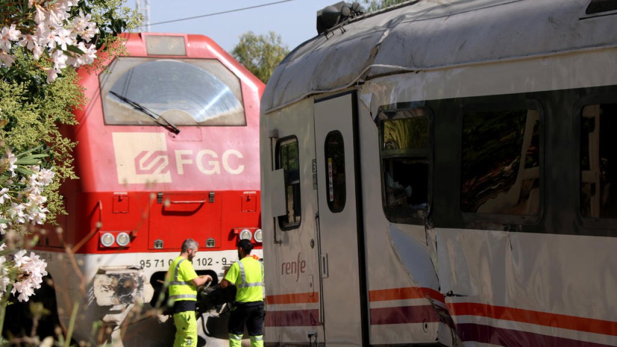 Operaris d'Adif i de Renfe fent tasques per retirar la locomotora accidentada en el xoc amb un tren regional a Vila-seca.