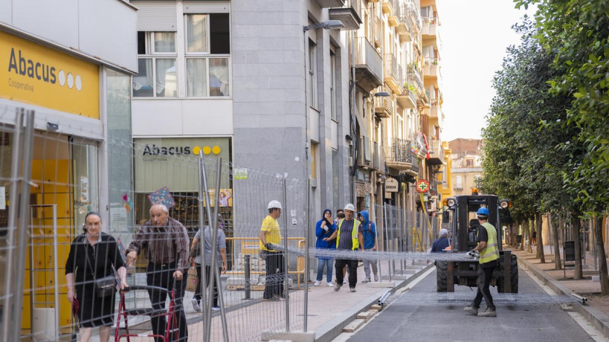 Els operaris, col·locant ahir les tanques al tram entre el carrer de Santa Anna i la plaça Catalunya.
