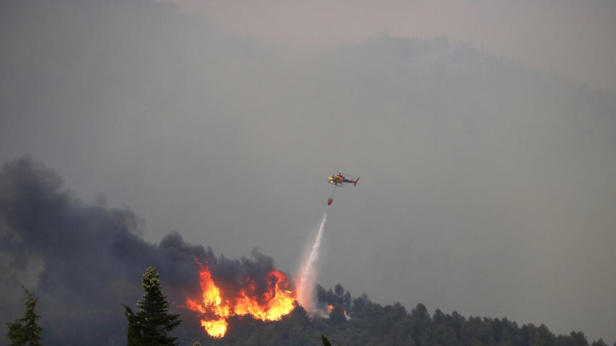 Imagen de las tareas de extinción de un helicóptero al incendio d'Artes aaquest dimeres.