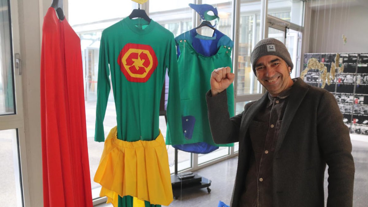 El artista Jordi Llort-Figuerola con los trajes de su alter ego, el superhéroe Plastic Hunter, en la exposición 'Distopies del plàstic'.