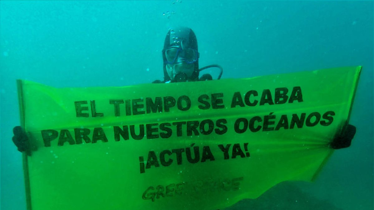 Un activista de Greenpeace despliega una pancarta submarina en la Mar Bella.