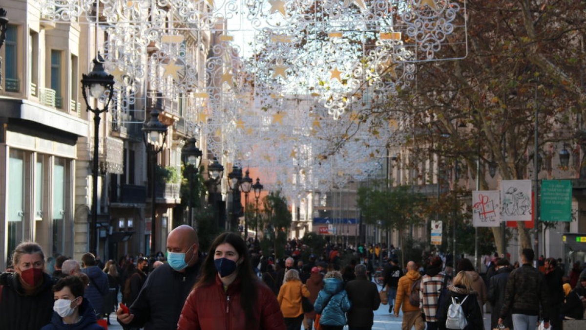 Gente con mascarilla paseando por el Portal de l'Àngel de Barcelona.