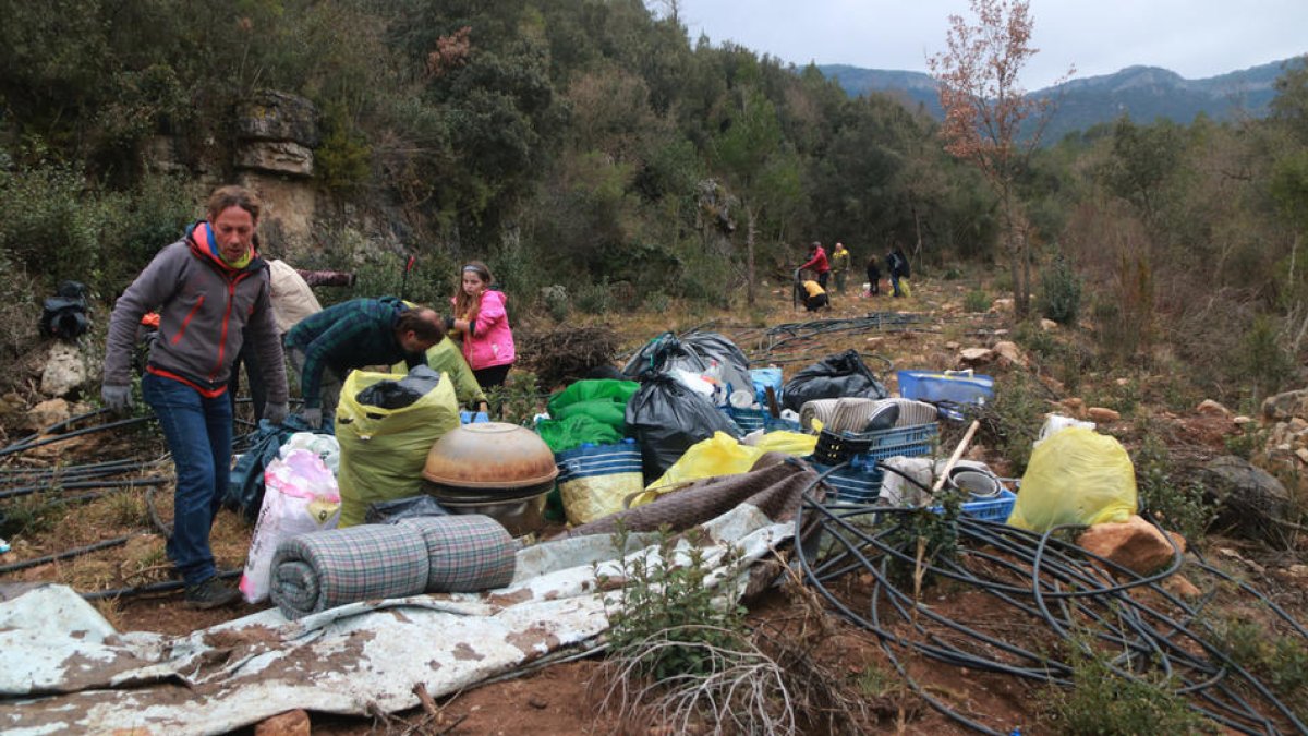 Voluntaris recollint les restes d'un campament d'una plantació de marihuana a Mont-ral.