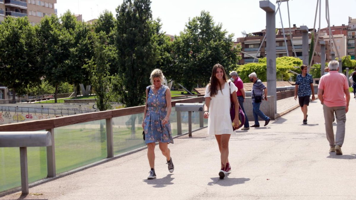 Dos chicas sin mascarilla paseando por la pasarela del río Segre en Lleida.