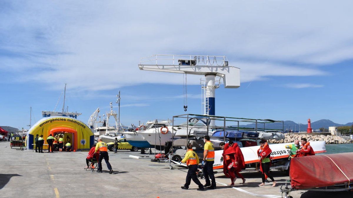 Els equips d'emergències atenent els afectats en el simulacre d'incendi en un catamarà al port de Cambrils.