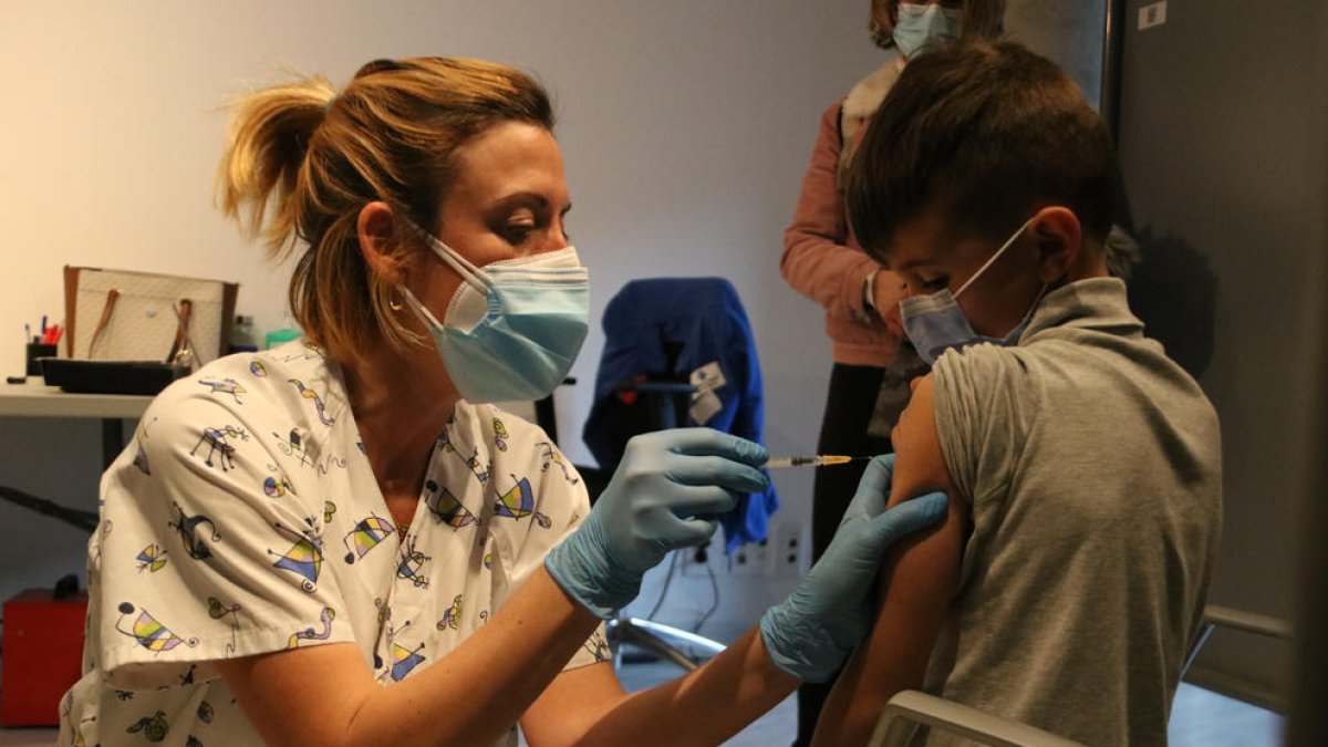 Una infermera administrant el vaccí contra la covid a un nen a Girona.