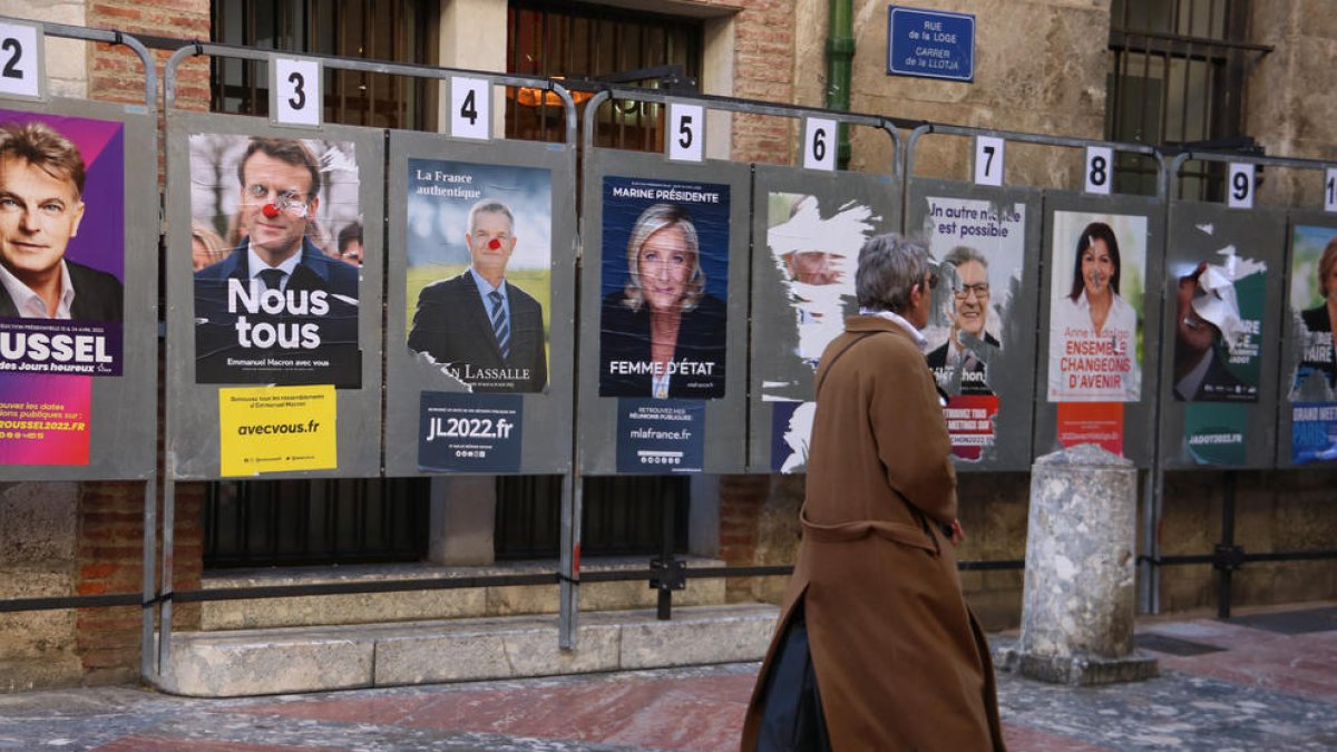 Un dona passant per davant de cartells electorals a Perpinyà.