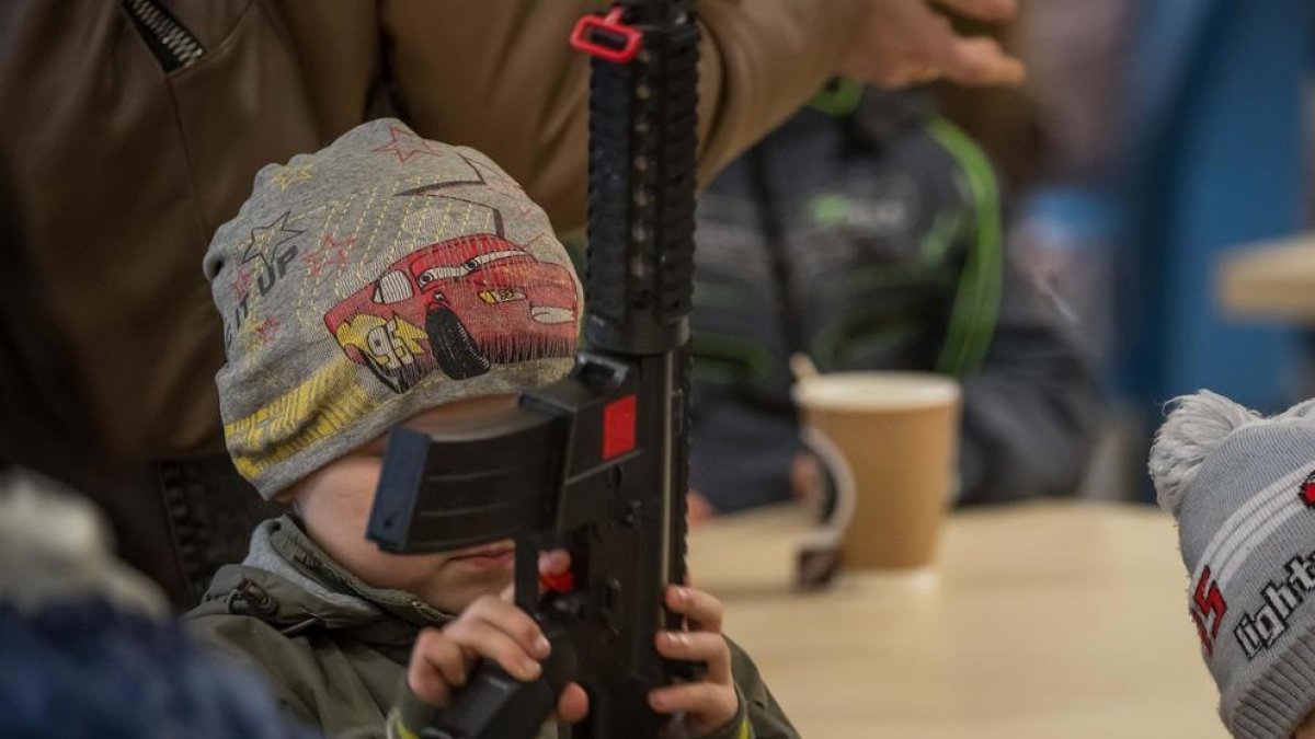 Un niño juega con una metralleta de juguete en una de las salas del estadio Arena Lviv reconvertidas en alojamiento para desplazados en Leópolis.